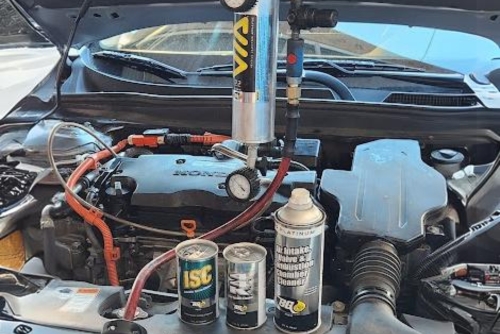Fuel system service near me in Los Angeles and Van Nuys, CA with Sean’s Auto Care. Image of a Honda with its hood open, displaying the engine and products used for fuel system service.