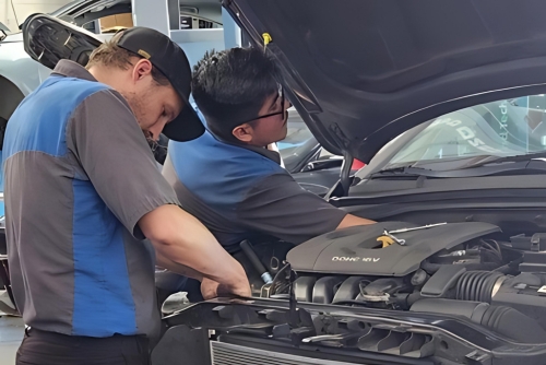 Cooling System Repair in Los Angeles and Van Nuys, CA with Sean’s Auto Care. Image of two technicians working on the cooling system repair of an open hood car.