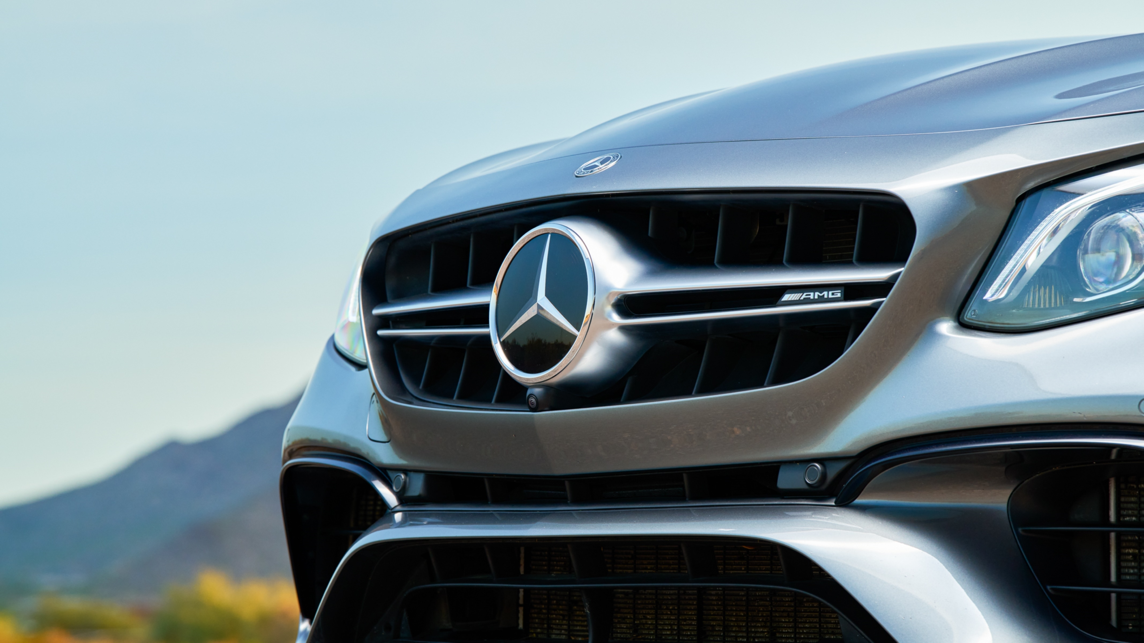 Mercedes Repair and Maintenance services in Van Nuys, CA with Sean's Auto Care. Image of the front grill of a silver newer model Mercedes with mountain scapes in the background.