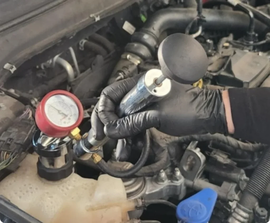 Cooling system service near me in Los Angeles and Van Nuys, CA with Sean’s Auto Care. Image of an open hood car with a mechanic's hands working on the cooling system.