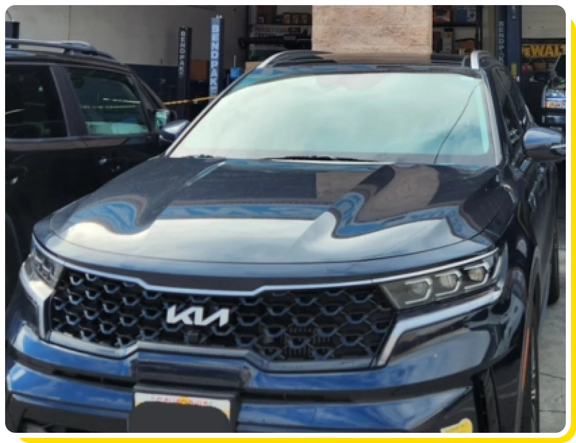 Hybrid repair and maintenance in Los Angeles and Van Nuys, CA with Sean’s Auto Care. Image of a KIA hybrid car parked at the garage of Sean’s Auto Care after undergoing hybrid car maintenance.