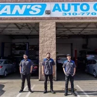 Image of 3 male mechanics posing outside of Sean's Auto Care Shop bays.